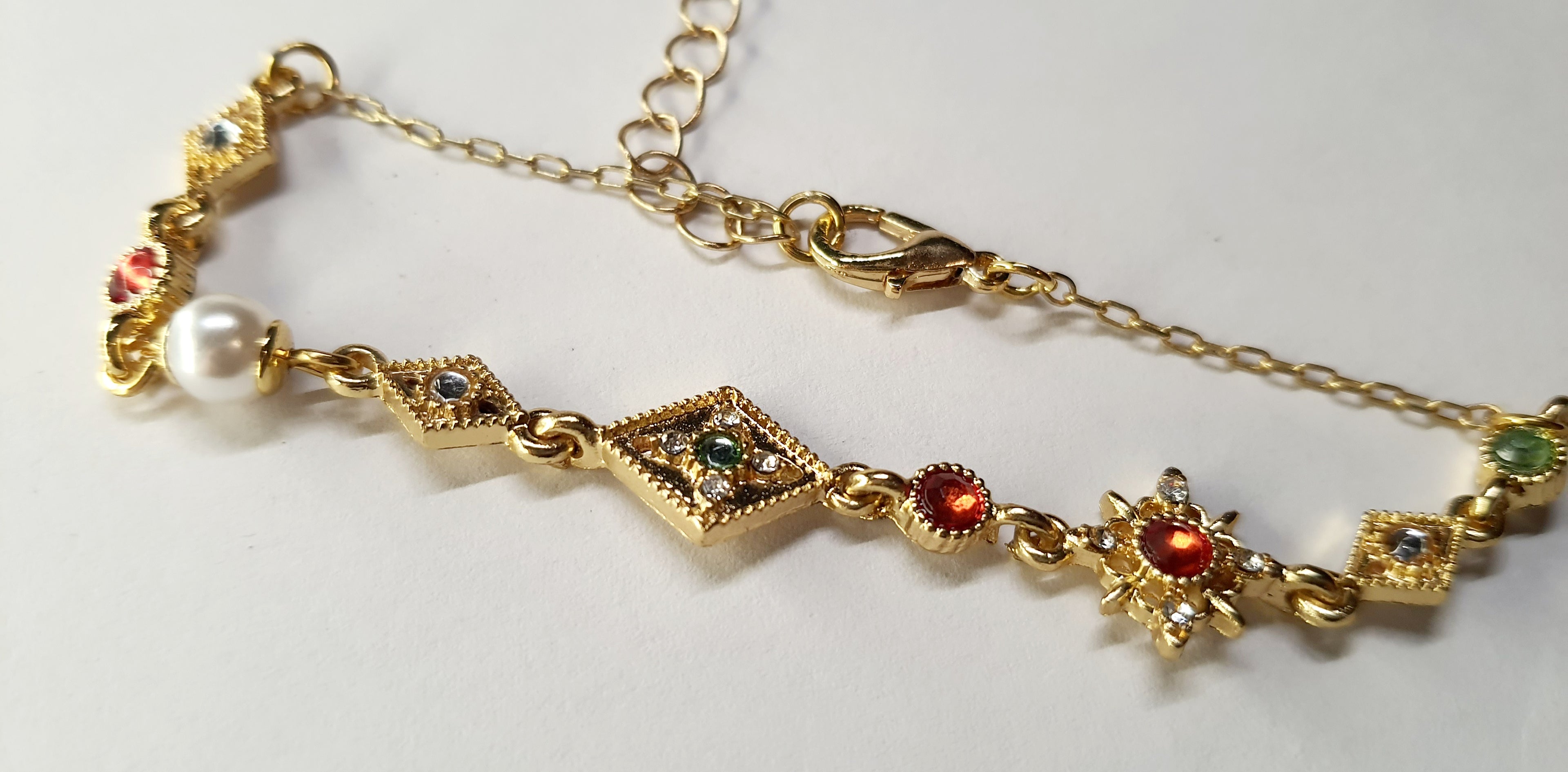 Złota bransoletka z kolorowymi kamieniami – czerwonymi, zielonymi i białymi, długość regulowana 18–25 cm, styl vintage orientalny. Stal nierdzewna, stal chirurgiczna, wodoodporne, hipoalergiczne, jakość premium, Rouge Bizu.