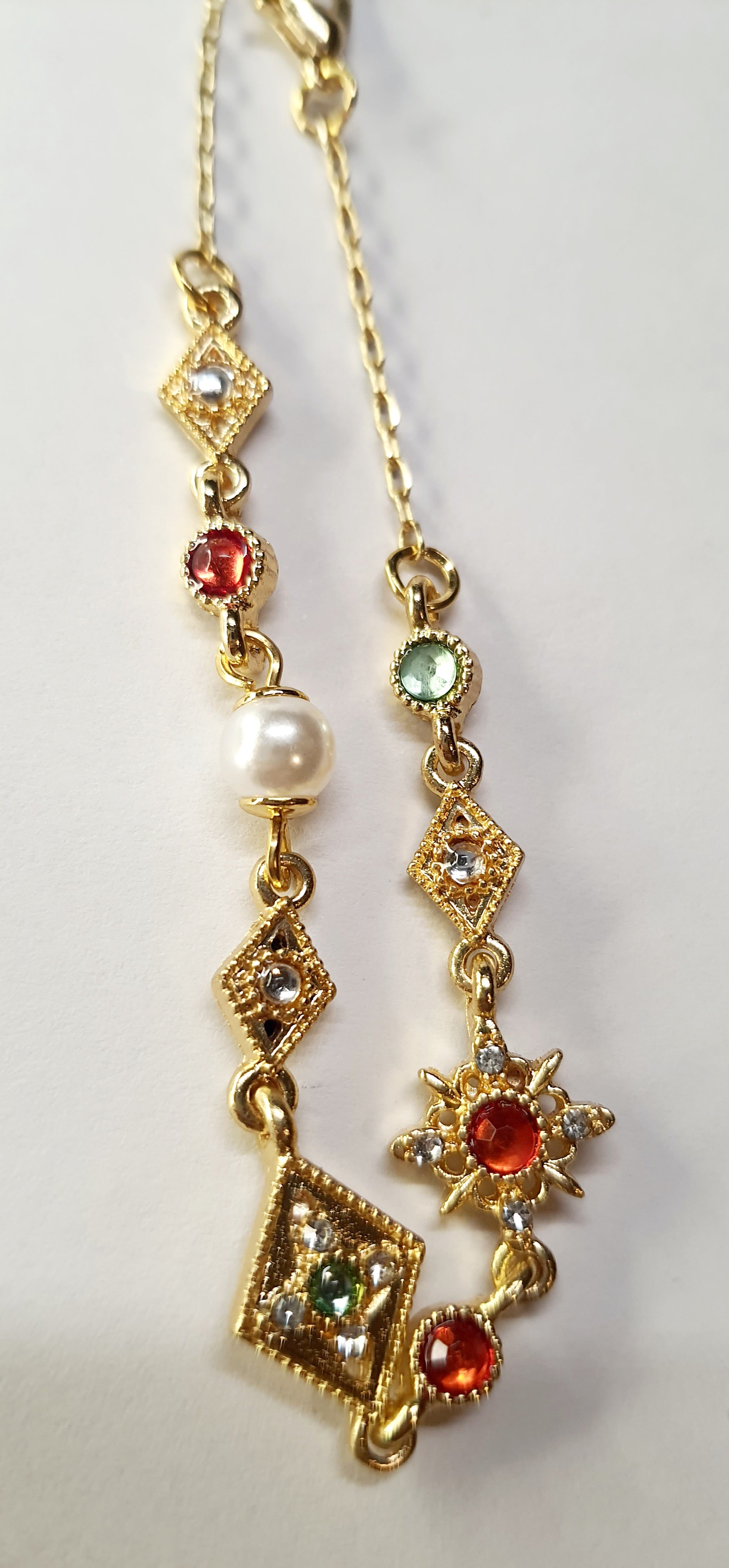 Złota bransoletka z kolorowymi kamieniami – czerwonymi, zielonymi i białymi, długość regulowana 18–25 cm, styl vintage orientalny. Stal nierdzewna, stal chirurgiczna, wodoodporne, hipoalergiczne, jakość premium, Rouge Bizu.