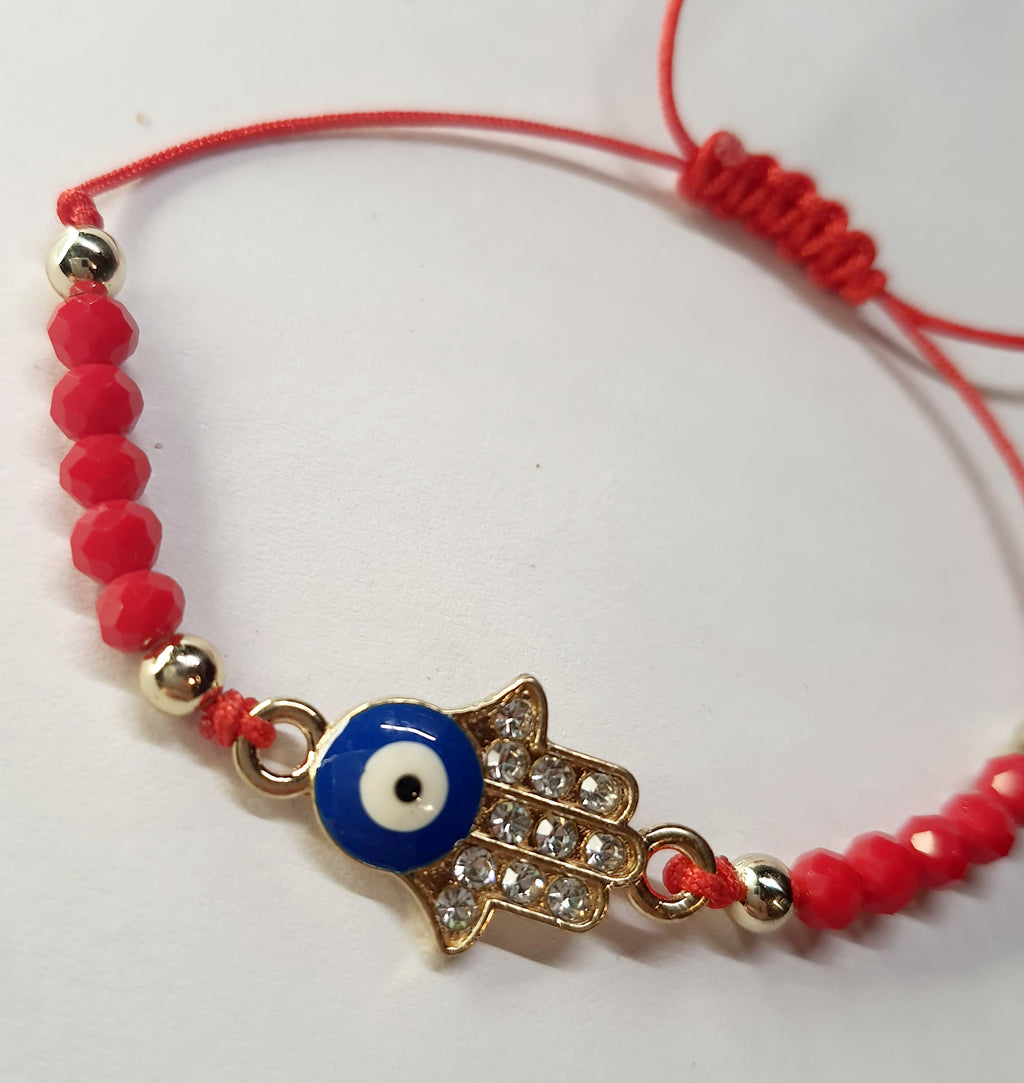 Bransoletka na czerwonym sznurku z zawieszką w kształcie dłoni Fatimy z okiem proroka, zdobioną cyrkoniami. Styl boho i amulet ochronny. Stal chirurgiczna, stal nierdzewna, wodoodporne, hipoalergiczne, jakość premium. Rouge Bizu.