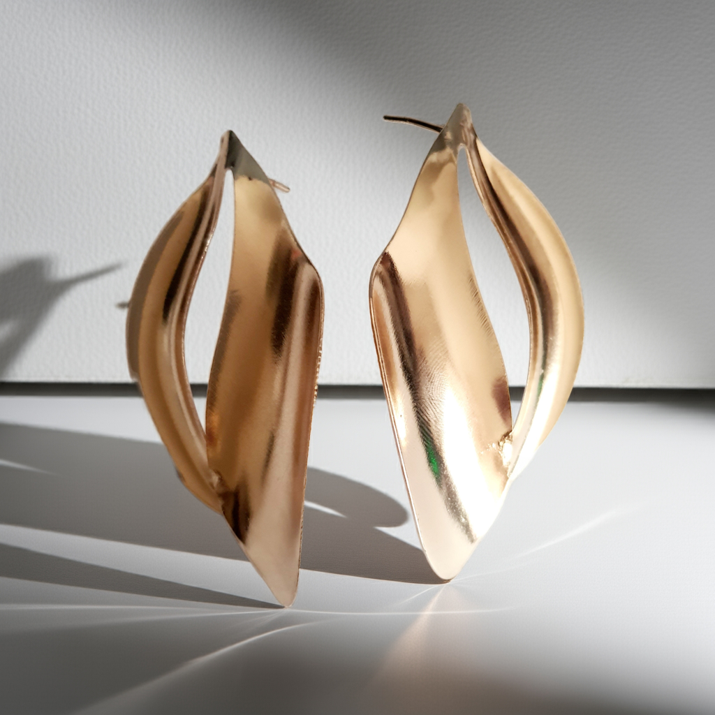 Kolczyki ze stali nierdzewnej w kolorze złotym o rzeźbiarskim kształcie fal. Długość 7 cm, na wkrętki. Eleganckie, lekkie i nowoczesne. Rouge Bizu.
