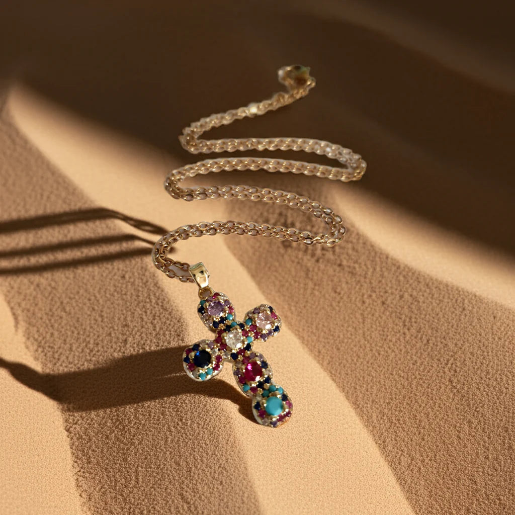 Złoty naszyjnik ze stali chirurgicznej z zawieszką w kształcie krzyża wysadzanego kolorowymi kryształami (czerwonymi, niebieskimi, fioletowymi, turkusowymi). Długość łańcuszka 50 cm. Stal chirurgiczna, stal nierdzewna, wodoodporne, hipoalergiczne, jakość premium. RougeBizu.