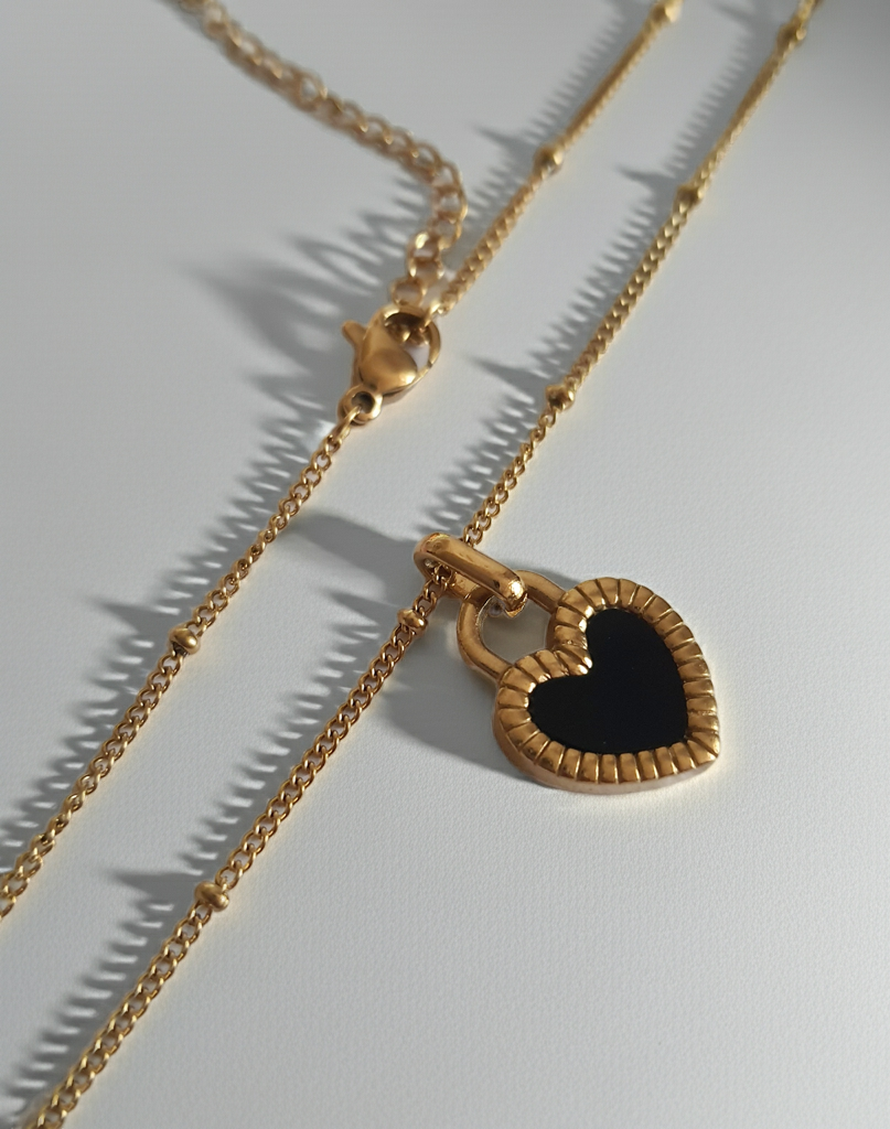 Złoty naszyjnik ze stali chirurgicznej z dwustronnym sercem – czarna i biała emalia. Regulowana długość 45–50 cm. Stal chirurgiczna, stal nierdzewna, wodoodporne, hipoalergiczne, jakość premium. RougeBizu.