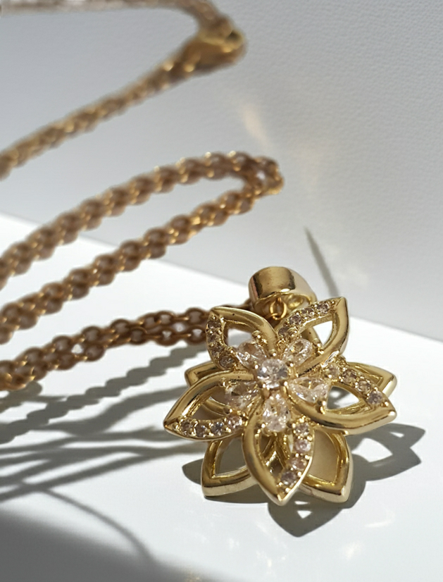 Złoty naszyjnik ze stali chirurgicznej z zawieszką w kształcie kwiatowej rozety wysadzanej cyrkoniami. Regulowana długość 45–50 cm. Stal chirurgiczna, stal nierdzewna, wodoodporne, hipoalergiczne, jakość premium. RougeBizu.