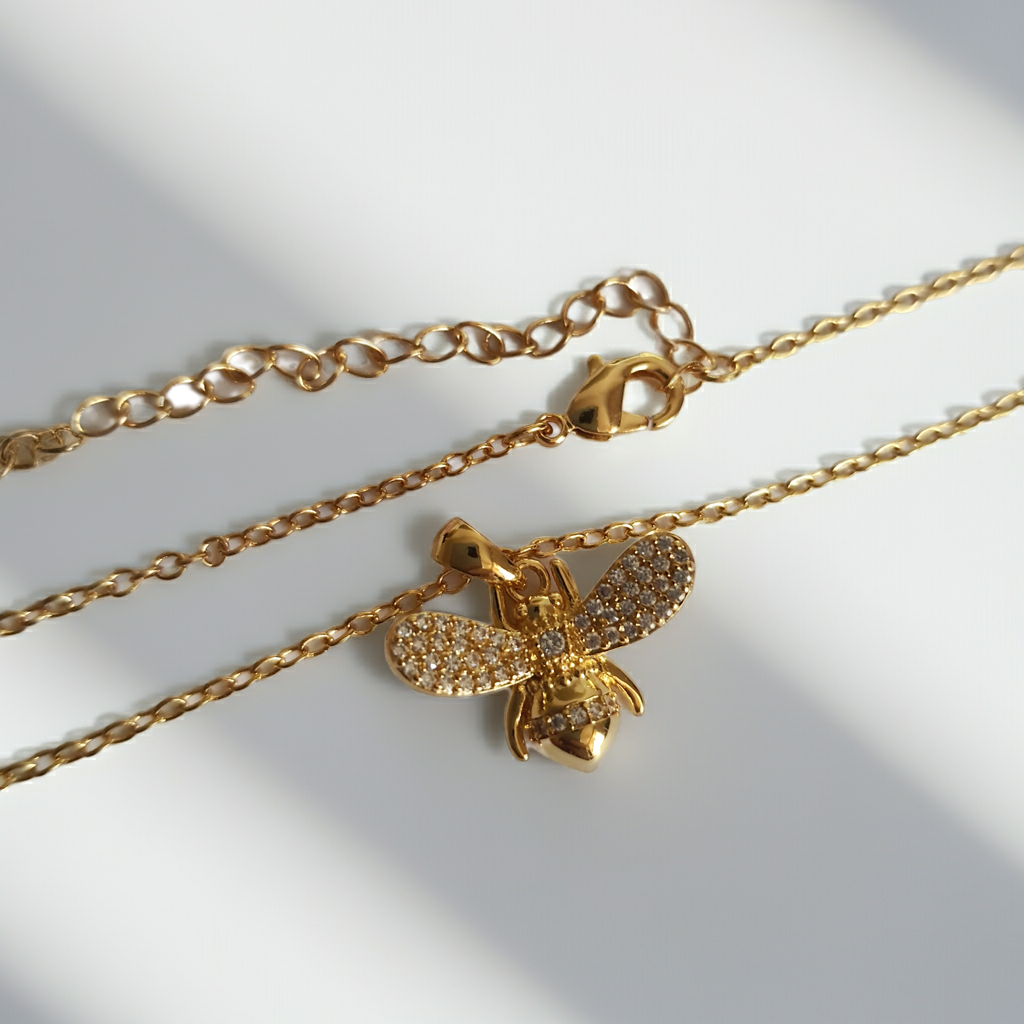 Złoty naszyjnik ze stali chirurgicznej z zawieszką w kształcie pszczółki wysadzanej cyrkoniami. Regulowana długość 40–45 cm. Stal chirurgiczna, stal nierdzewna, wodoodporne, hipoalergiczne, jakość premium. RougeBizu.