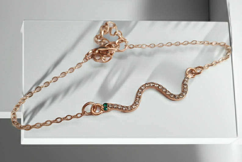 Bransoletka żmijka z cyrkoniami, złota, z zielonymi oczkami węża, długość 20–25 cm. Mistyczna, przyciągająca spojrzenia. Stal nierdzewna. Rouge Bizu.

