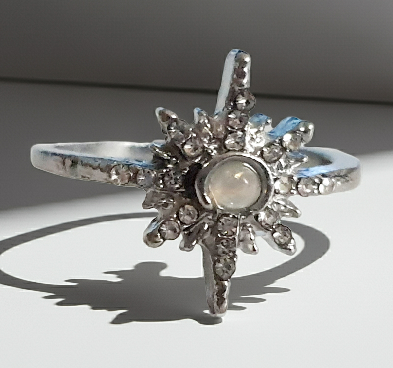 Srebrny pierścionek ze stali nierdzewnej i chirurgicznej z opalizującym kamieniem i cyrkoniami w kształcie gwiazdy, styl glamour i romantyczny, rozmiar 18 mm. Wodoodporny, hipoalergiczny, jakość premium. Rouge Bizu.