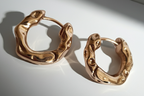Gold earrings with a pearl disc – a modern classic