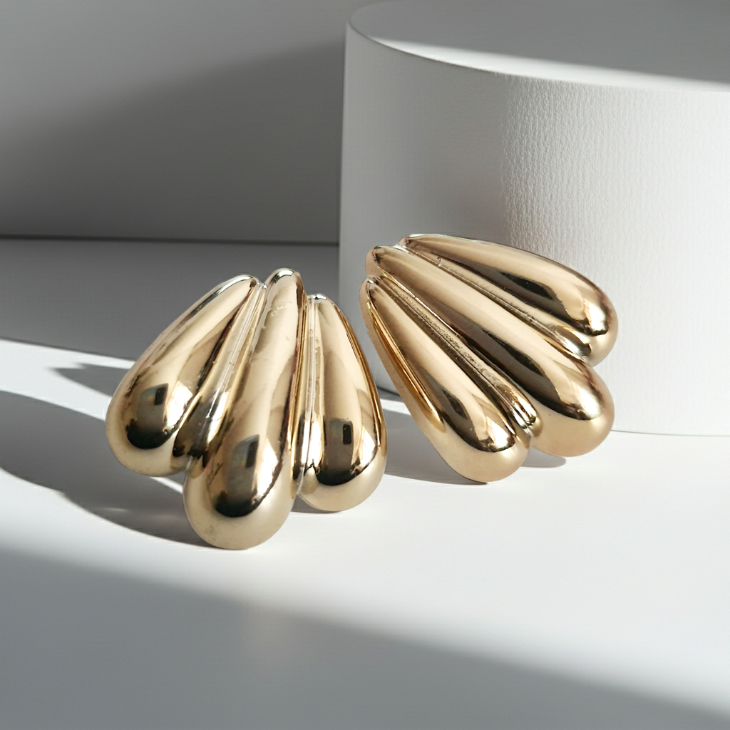 Kolczyki złote wkrętki o długości 2,5 cm, masywna forma przypominająca skrzydła lub rzeźbione łzy, styl vintage, glamour, stal chirurgiczna, elegancja i blask. Rouge Bizu.
