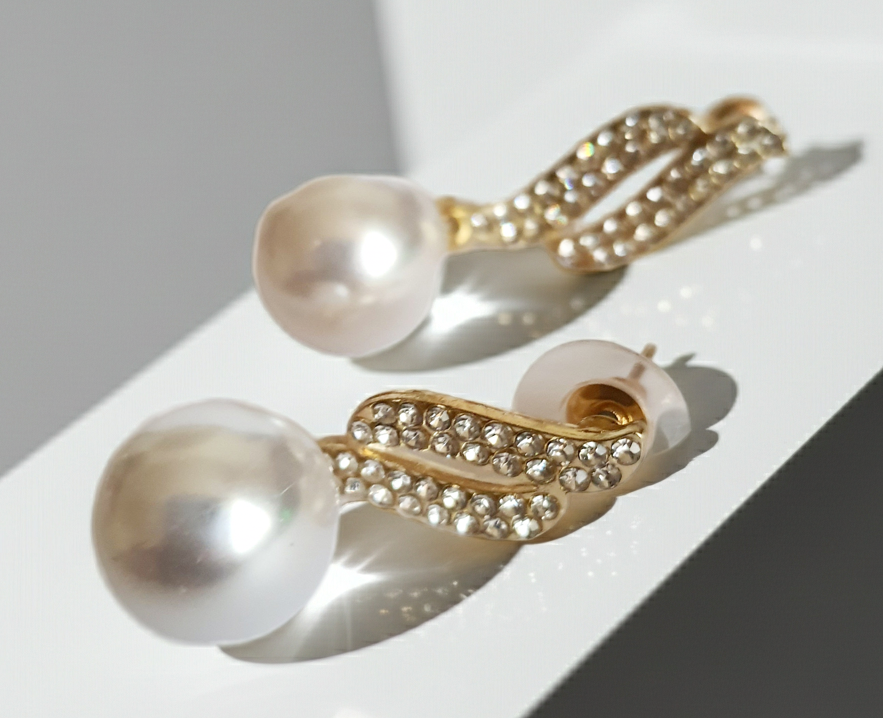 Kolczyki złote ze stali nierdzewnej o długości 4 cm, z dużą białą perłą i złotą falą wysadzaną cyrkoniami, elegancja i blask, Rouge Bizu.