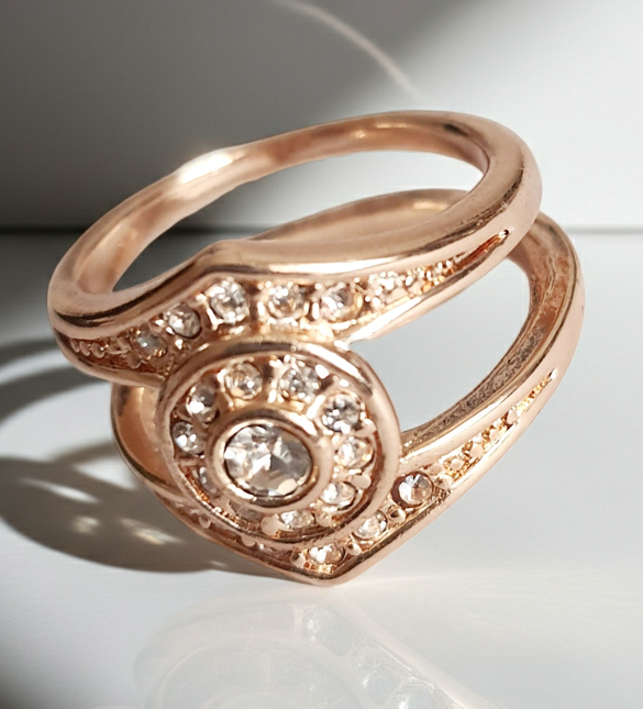 Złoty pierścionek ze stali chirurgicznej z okrągłym bezbarwnym kryształem w centrum, otoczonym drobnymi cyrkoniami. Podwójna obrączka, klasyczny styl. Rozmiar 16 mm. Rouge Bizu.
