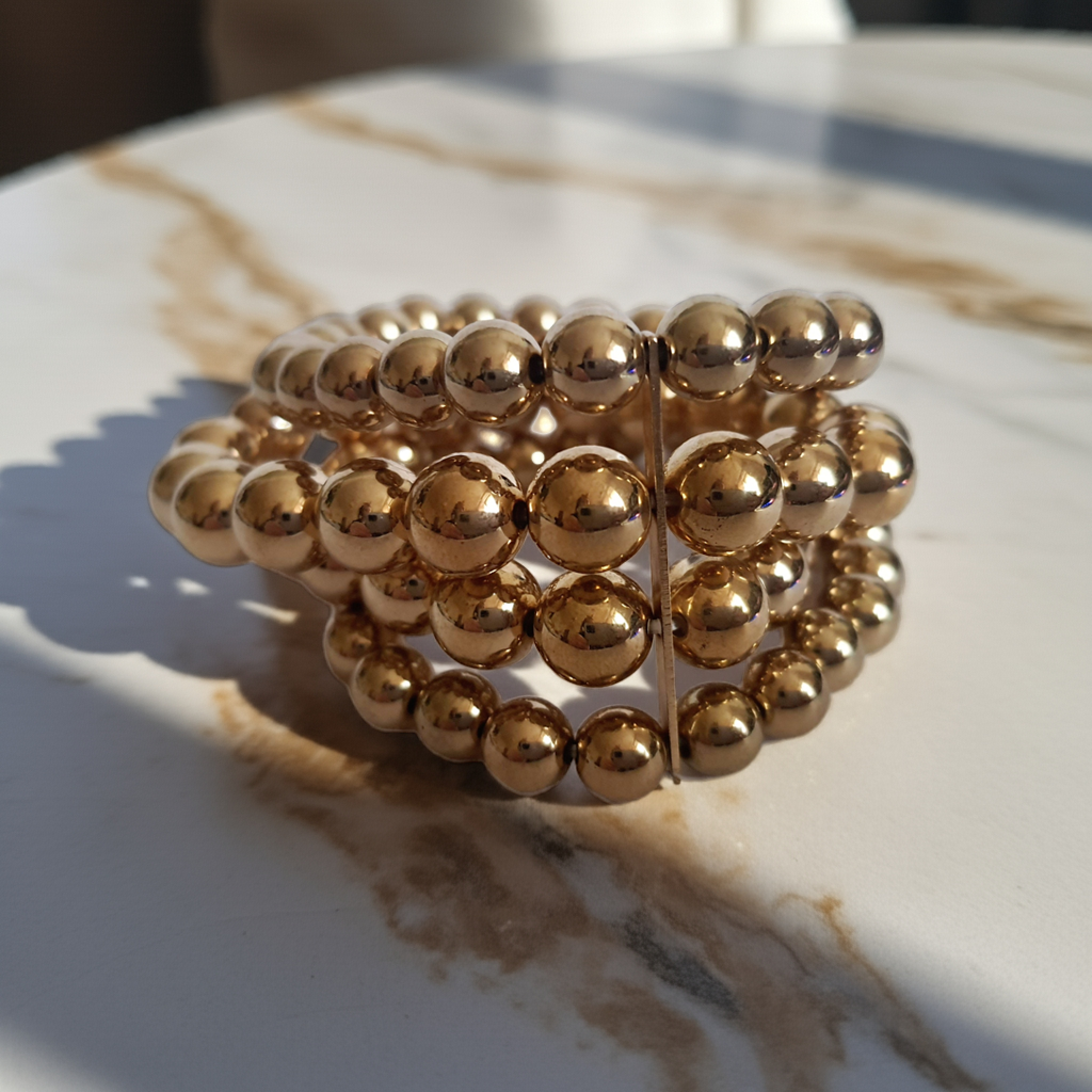 Bransoleta elastyczna na gumce z wielorzędowych złotych koralików, elegancka i klasyczna, Rouge Bizu.
