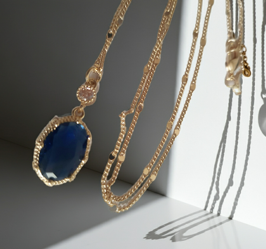 Złoty naszyjnik ze stali chirurgicznej z granatowym kamieniem w ozdobnej ramce i małą cyrkonią. Długość 47 cm. Stal chirurgiczna, stal nierdzewna, wodoodporne, hipoalergiczne, jakość premium. RougeBizu.