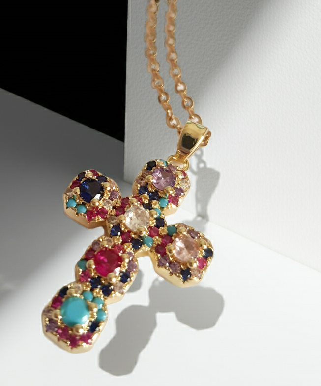 Złoty naszyjnik ze stali chirurgicznej z zawieszką w kształcie krzyża wysadzanego kolorowymi kryształami (czerwonymi, niebieskimi, fioletowymi, turkusowymi). Długość łańcuszka 50 cm. Stal chirurgiczna, stal nierdzewna, wodoodporne, hipoalergiczne, jakość premium. RougeBizu.