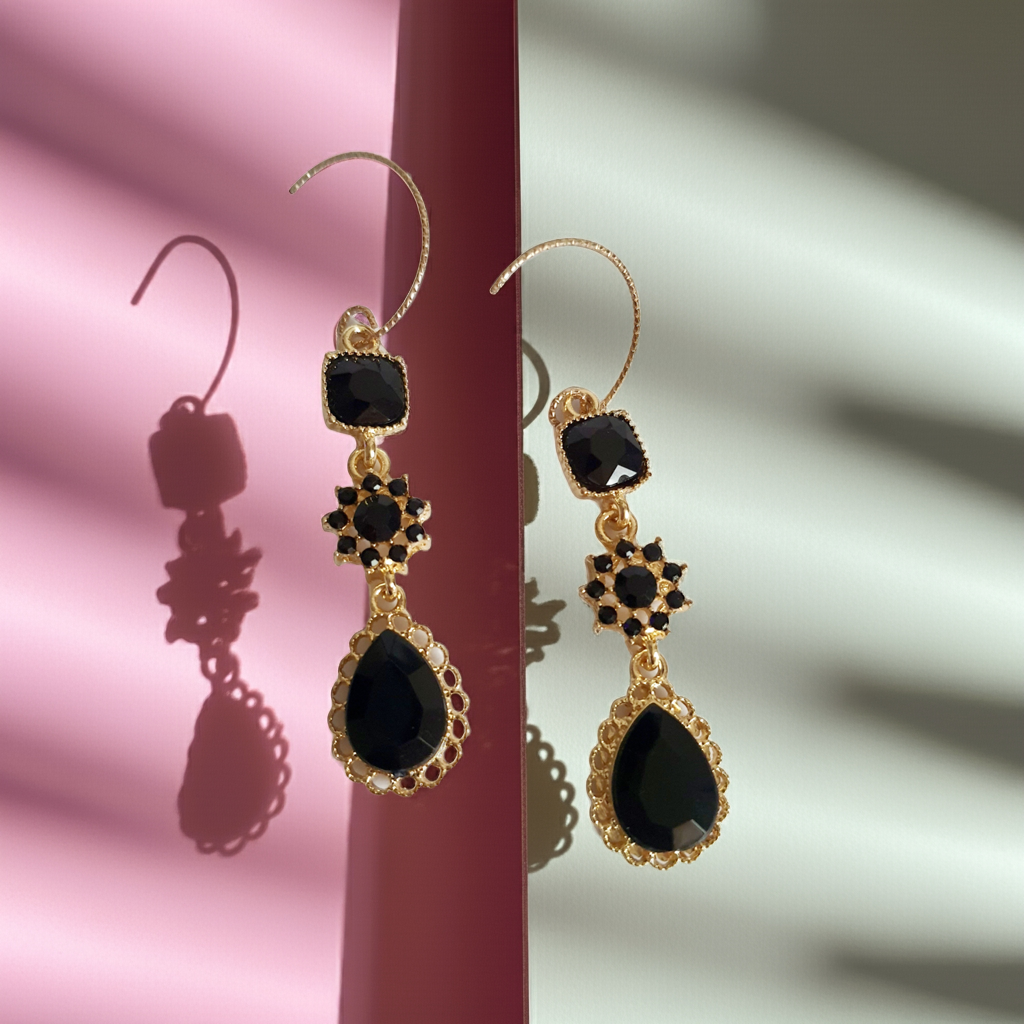 Kolczyki długie ze stali nierdzewnej w kolorze złota z czarnymi kamieniami. Zdobienia w formie kwadratu, rozetki i kropli. Długość 5 cm bez bigla, 6,5 cm z biglem. Styl glamour i elegancki. Rouge Bizu.