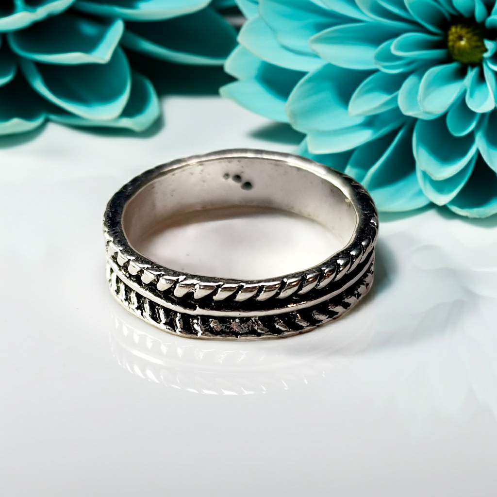 Produkt umieszczony na czystej białej powierzchni, przy białej ścianie, w minimalistycznym otoczeniu. W jasnym oświetleniu studyjnym, które tworzy subtelny, eteryczny klimat. Subtelne refleksy i równo rozprowadzone cienie podkreślają kontury. Styl fotografii redakcyjnej. W tle widoczne lekko rozmyte TURKUSOWE kwiaty, efekt romatyczny
