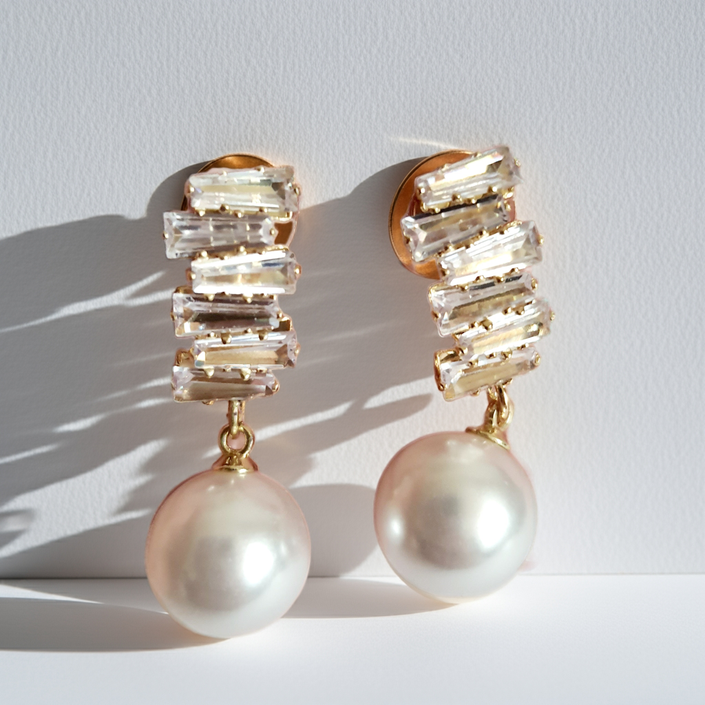 Złote kolczyki ze stali nierdzewnej z cyrkoniami i dużą perłą syntetyczną, długość 3 cm, elegancki styl glamour. Rouge Bizu.