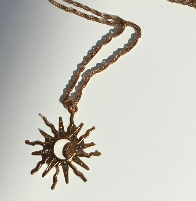 Naszyjnik ze stali nierdzewnej w kolorze złotym, z zawieszką w kształcie słońca i księżyca ozdobioną kryształkami, długość łańcuszka 42–47 cm, Rouge Bizu.