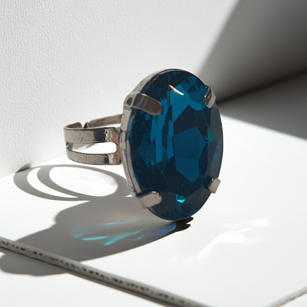Srebrny pierścionek z dużym granatowo-niebieskim owalnym kamieniem, metal, szlifowany kamień o głębokim blasku, elegancki styl, regulowany rozmiar, Rouge Bizu.