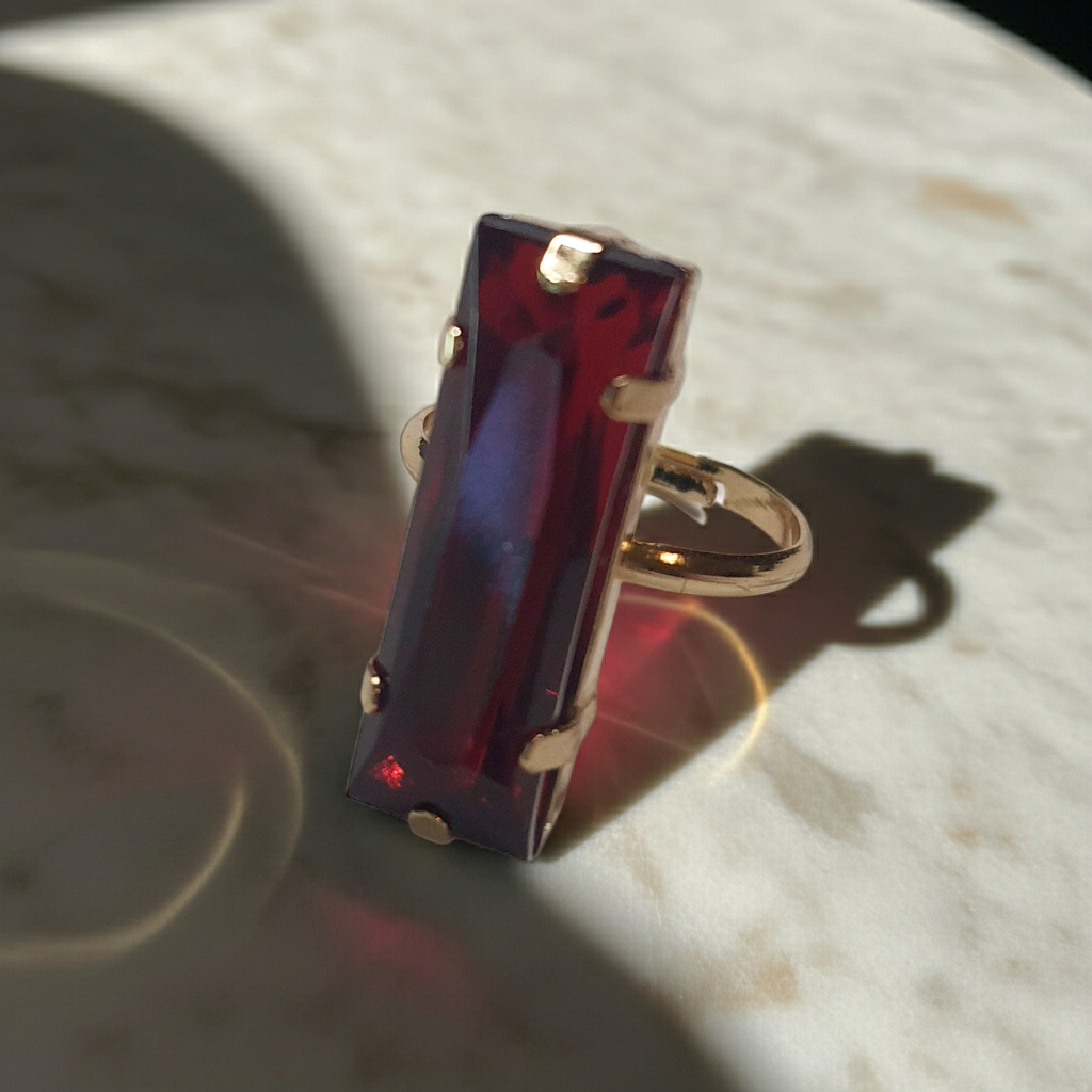Złoty pierścionek z długim rubinowym kamieniem w stylu glamour, elegancki i efektowny. Rozmiar 17 mm, lekko regulowany. Stal nierdzewna, stal chirurgiczna, wodoodporne, hipoalergiczne, jakość premium. Rouge Bizu.