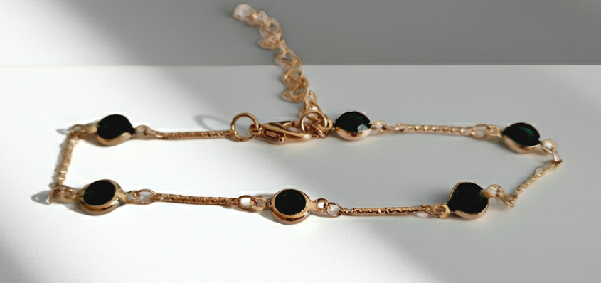 Bransoletka z szmaragdowymi cyrkoniami, złoty łańcuszek, regulowana długość 20–25 cm. Delikatna, elegancka, klasyczna biżuteria ze stali nierdzewnej. Rouge Bizu.
