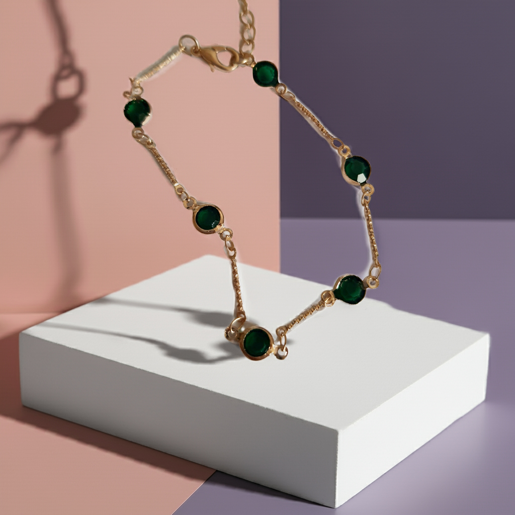 Bransoletka z szmaragdowymi cyrkoniami, złoty łańcuszek, regulowana długość 20–25 cm. Delikatna, elegancka, klasyczna biżuteria ze stali nierdzewnej. Rouge Bizu.

