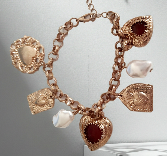 Złota bransoletka w stylu vintage z charmsami: serca, symbole sakralne, perłowe zawieszki. Stal chirurgiczna, długość regulowana 20–28 cm. Klasyka, romantyzm i mistyczna elegancja. Rouge Bizu.
