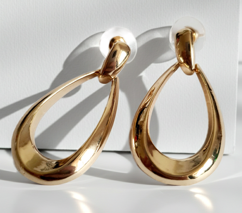 Złote kolczyki ze stali nierdzewnej w kształcie minimalistycznych kropli, eleganckie i ponadczasowe, długość 4 cm. Rouge Bizu.