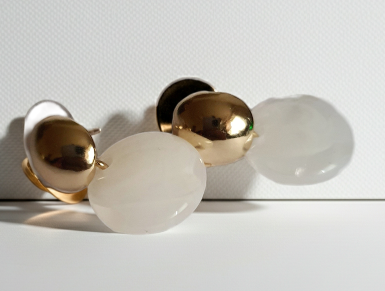 „Złote kolczyki ze stali nierdzewnej o długości 2,5 cm, z perłowym dyskiem zawieszonym na złotym sztyfcie, minimalistyczne i eleganckie – Rouge Bizu.”