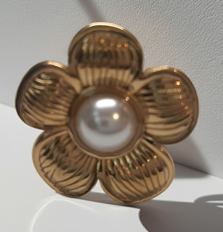 Złoty pierścionek w kształcie kwiatu z białą perłą w centrum, elegancki i kobiecy. Rozmiar 17 mm, regulowany. Stal nierdzewna, stal chirurgiczna, wodoodporne, hipoalergiczne, jakość premium. Rouge Bizu.