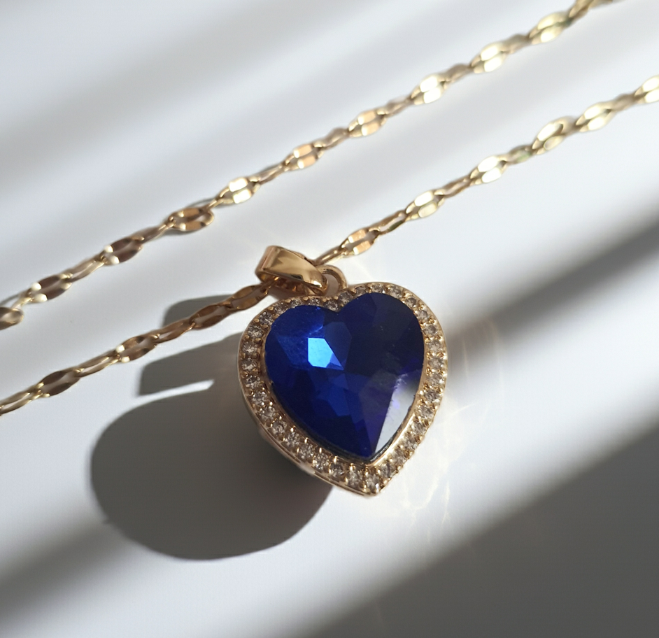 Naszyjnik złoty ze stali nierdzewnej – stal chirurgiczna, wodoodporny, hipoalergiczny, jakość premium. Zawieszka w kształcie serca w kolorze szafirowego błękitu, otoczona drobnymi cyrkoniami. Długość łańcuszka 40–45 cm. Elegancja i styl RougeBizu.