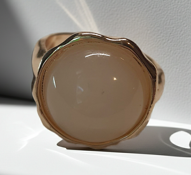 Złoty pierścionek z mlecznym kamieniem w falowanej oprawie, delikatny i elegancki. Rozmiar 17 mm, lekko regulowany. Stal nierdzewna, stal chirurgiczna, wodoodporne, hipoalergiczne, jakość premium. Rouge Bizu.