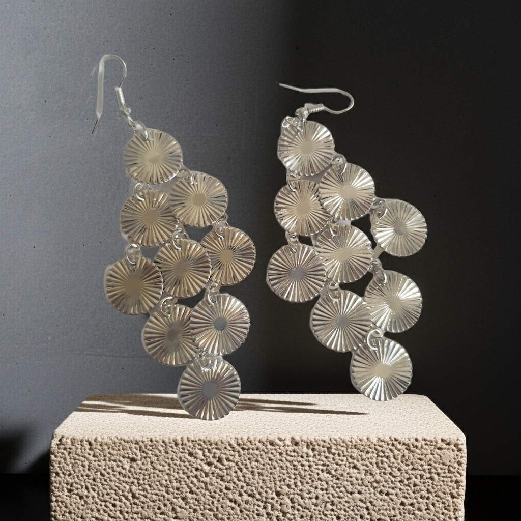 Srebrne kolczyki wiszące z promienistych dysków na biglu, wykonane ze stali nierdzewnej. Lekka, ruchoma forma z błyszczącym wykończeniem. Styl glamour i elegancja. Rouge Bizu.
