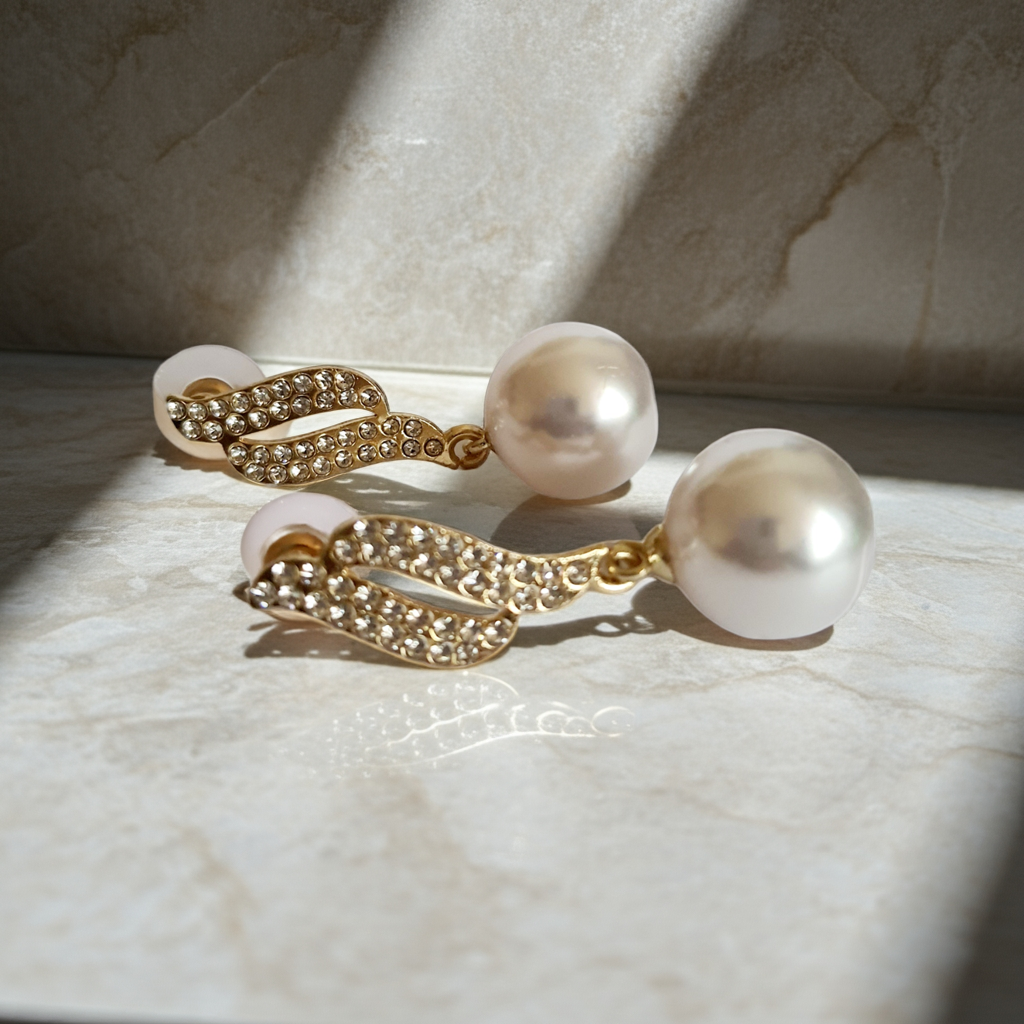 Kolczyki złote ze stali nierdzewnej o długości 4 cm, z dużą białą perłą i złotą falą wysadzaną cyrkoniami, elegancja i blask, Rouge Bizu.