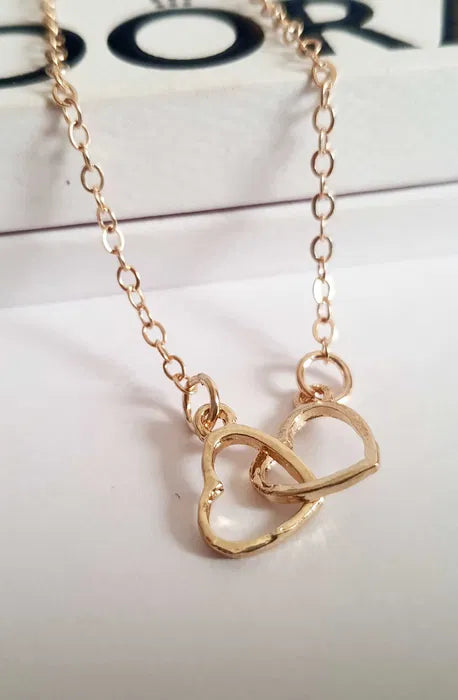 Złoty łańcuszek celebrytka z zawieszką z dwóch przeplatających się serduszek, długość 47–53 cm, wykonany ze stali chirurgicznej.

