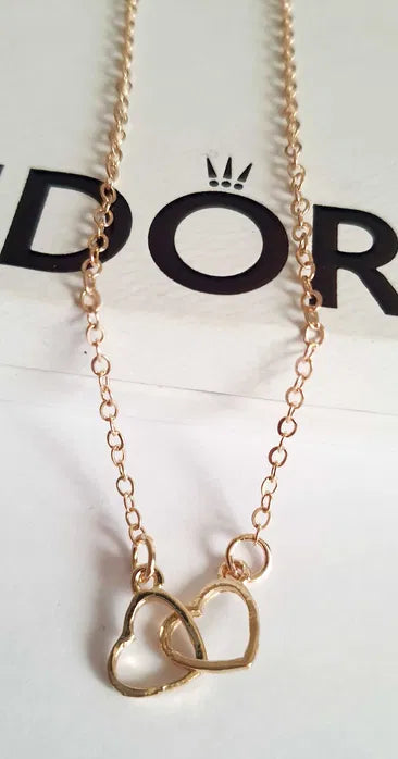 Złoty łańcuszek celebrytka z zawieszką z dwóch przeplatających się serduszek, długość 47–53 cm, wykonany ze stali chirurgicznej.

