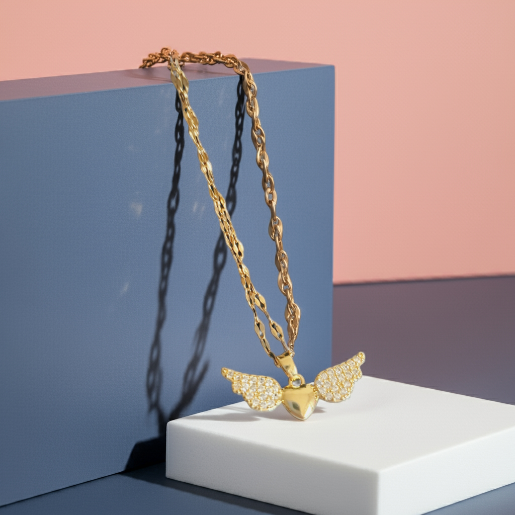 Naszyjnik ze stali nierdzewnej w kolorze złotym, z zawieszką w kształcie serca ze skrzydłami wysadzanymi kryształami, długość łańcuszka 40–45 cm, Rouge Bizu.