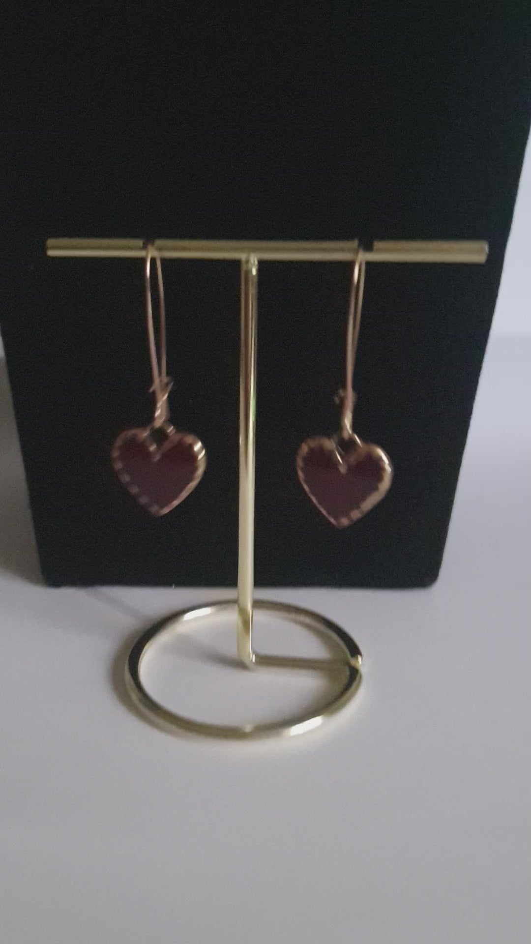 Kolczyki wiszące ze stali nierdzewnej w kolorze złota, z zawieszkami w kształcie czerwonych serc. Długość 5 cm. Styl romantyczny i elegancki. Rouge Bizu.